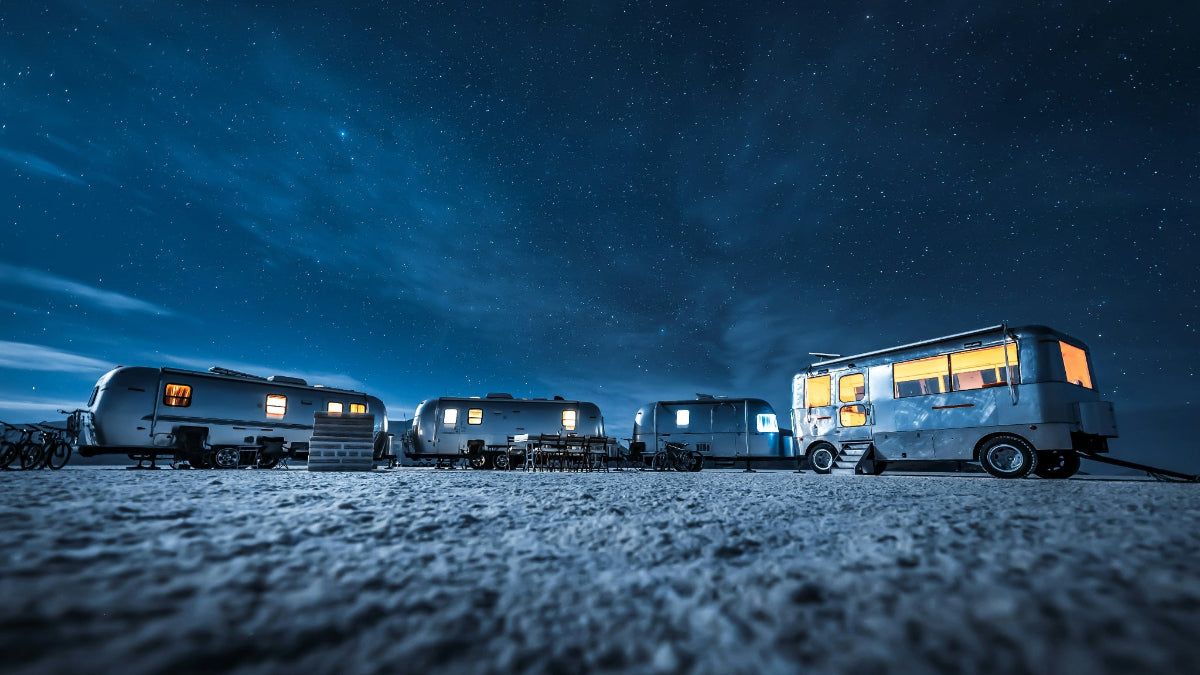 Row of recreational vehicle campers lit up by HAVEN solar portable lantern at a campsite under a starry night sky 