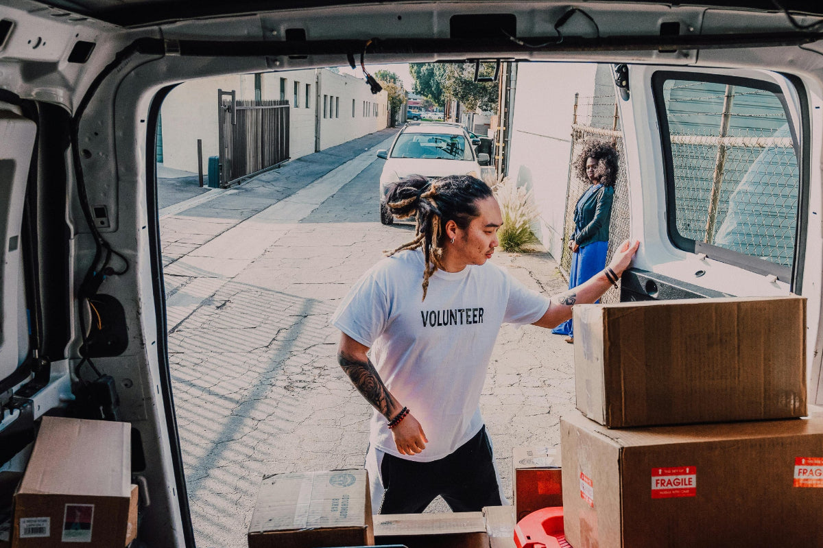 Volunteer unloading HAVEN solar portable lanterns and power banks and other disaster relief supplies after an emergency showcasing the power of corporations to engage in corporate social responsibility or CSR.