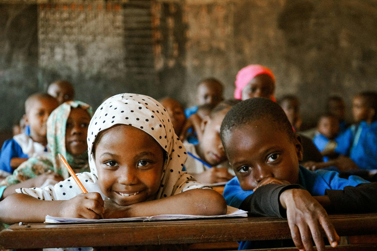 Children in a classroom setting in Africa working at their desks.